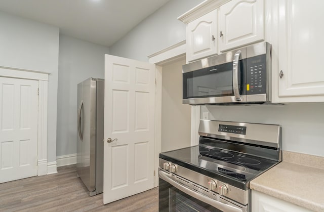 kitchen with white cabinetry, light hardwood / wood-style flooring, and stainless steel appliances