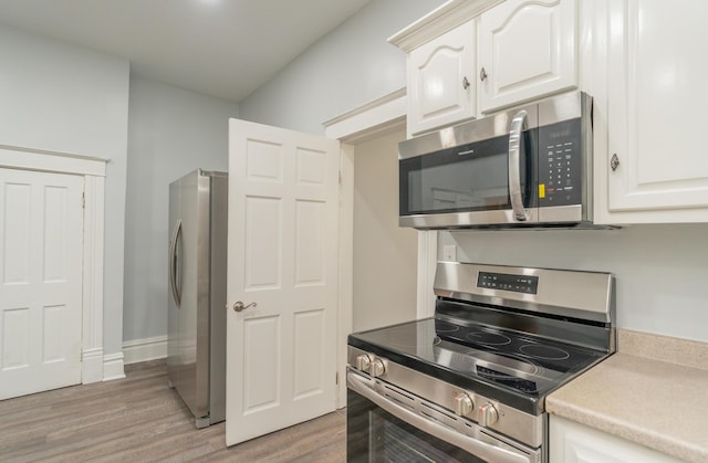 kitchen featuring appliances with stainless steel finishes, light wood-style flooring, light countertops, and white cabinets
