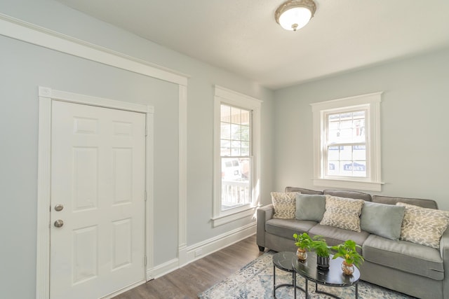 living room with dark wood-style flooring, healthy amount of natural light, and baseboards