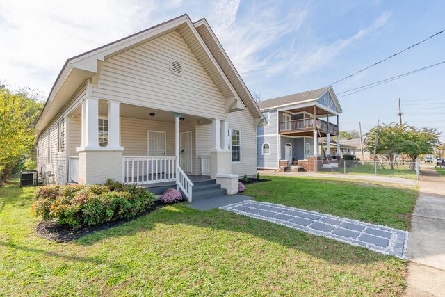 view of front of home with covered porch, brick siding, and central AC unit