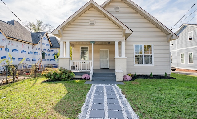 bungalow featuring a front lawn and a porch