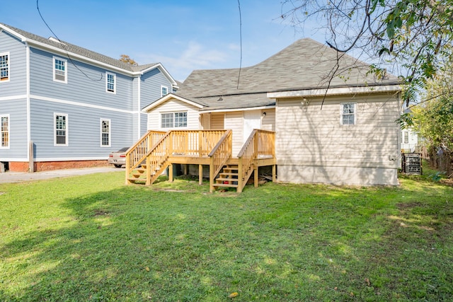 back of property with a yard and a wooden deck