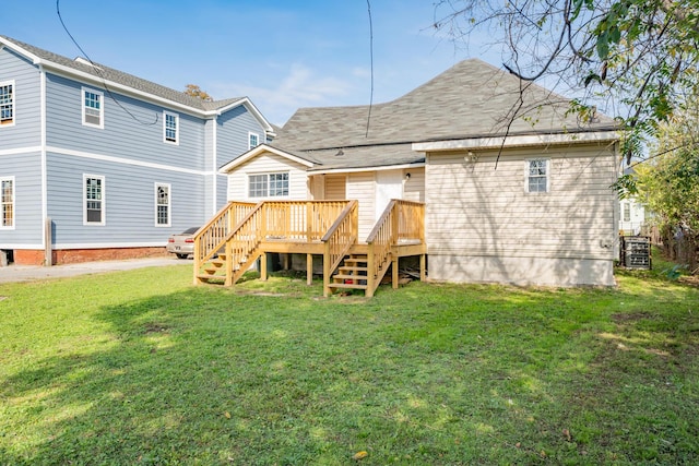 rear view of property with stairway, a lawn, and a wooden deck
