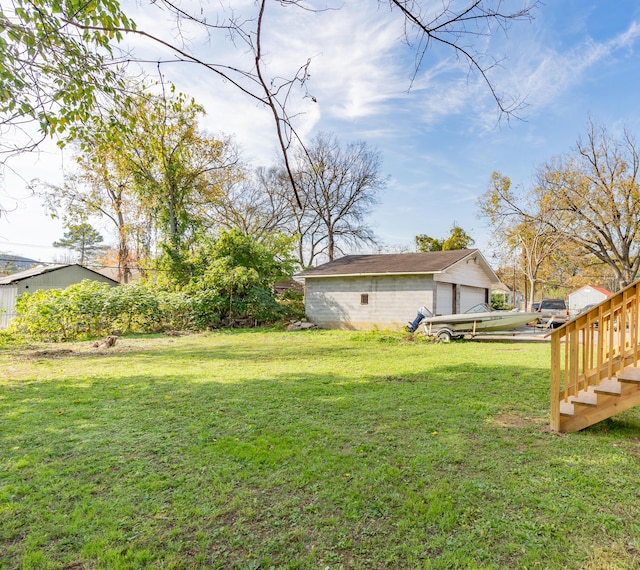 view of green lawn featuring an outdoor structure and a garage
