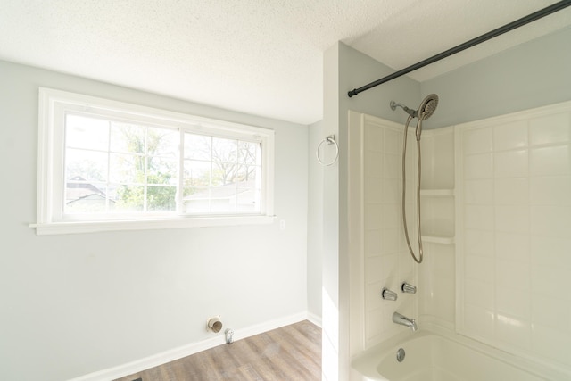 bathroom with tiled shower / bath, wood-type flooring, a textured ceiling, and plenty of natural light