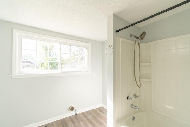 full bathroom featuring wood finished floors, bathing tub / shower combination, a textured ceiling, and baseboards