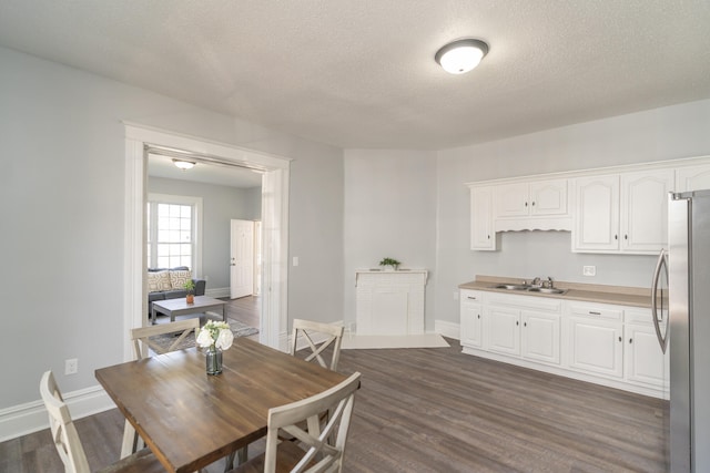 dining room featuring a textured ceiling, sink, and dark hardwood / wood-style floors