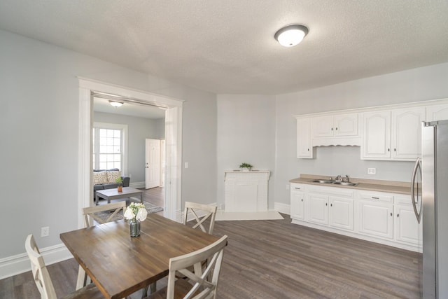 dining room with baseboards, dark wood-type flooring, and a textured ceiling