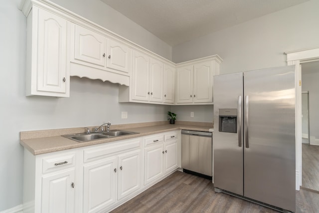 kitchen with sink, dark hardwood / wood-style floors, a textured ceiling, white cabinets, and appliances with stainless steel finishes