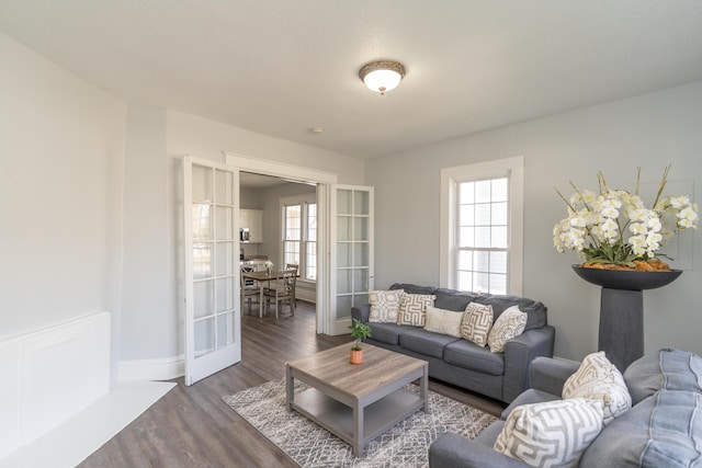 living room with french doors, dark wood-style floors, and baseboards