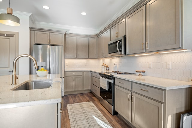 kitchen featuring dark wood-type flooring, crown molding, hanging light fixtures, light stone countertops, and appliances with stainless steel finishes