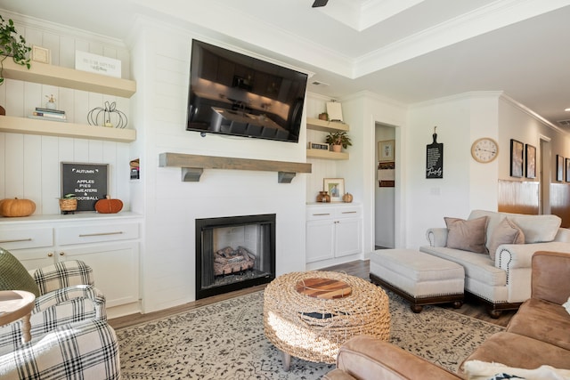 living room with a large fireplace, crown molding, and light hardwood / wood-style flooring