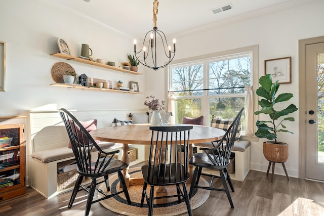 dining area featuring a notable chandelier, dark hardwood / wood-style floors, and ornamental molding