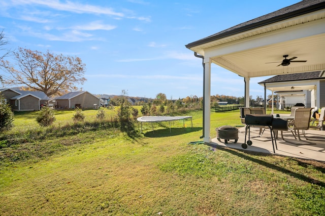 view of yard featuring a trampoline, ceiling fan, and a patio area