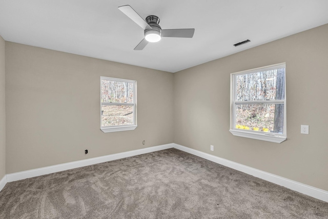 carpeted spare room with ceiling fan