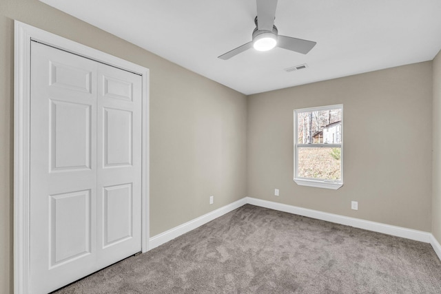 unfurnished bedroom featuring ceiling fan, light colored carpet, and a closet