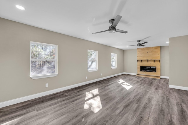 unfurnished living room with a stone fireplace and wood-type flooring