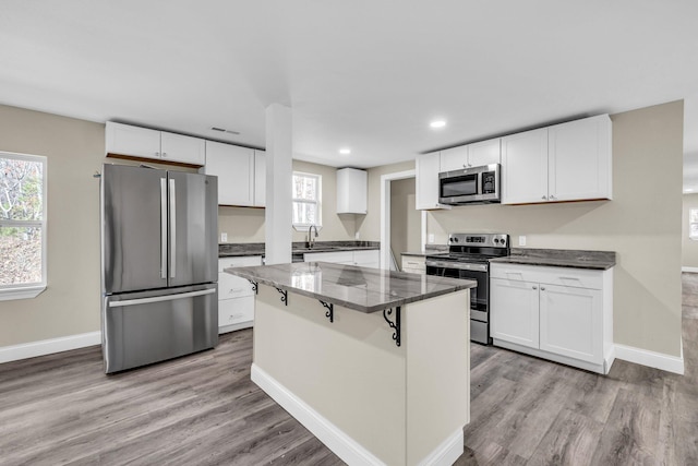 kitchen with sink, white cabinetry, appliances with stainless steel finishes, and a center island