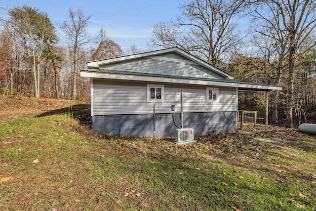 view of side of property with ac unit and a yard