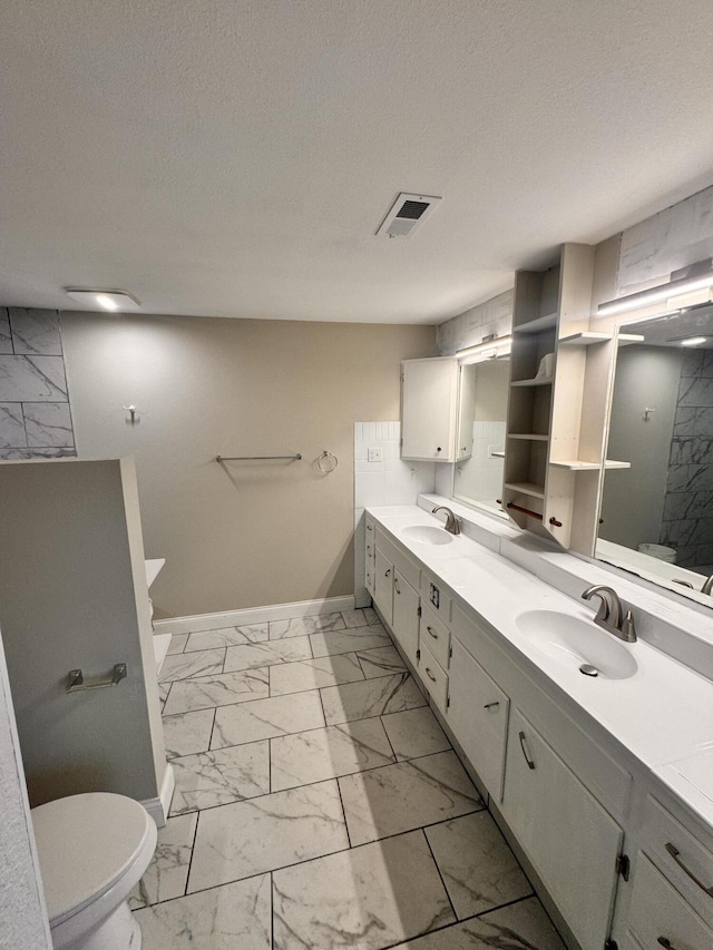 bathroom featuring vanity, toilet, walk in shower, and a textured ceiling