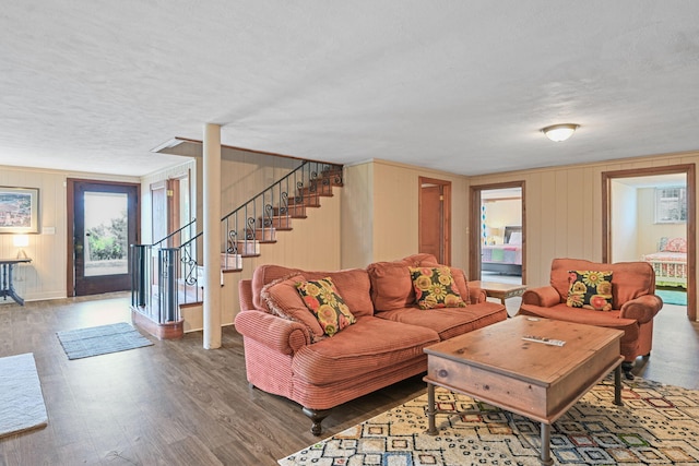 living room with a textured ceiling and dark wood-type flooring