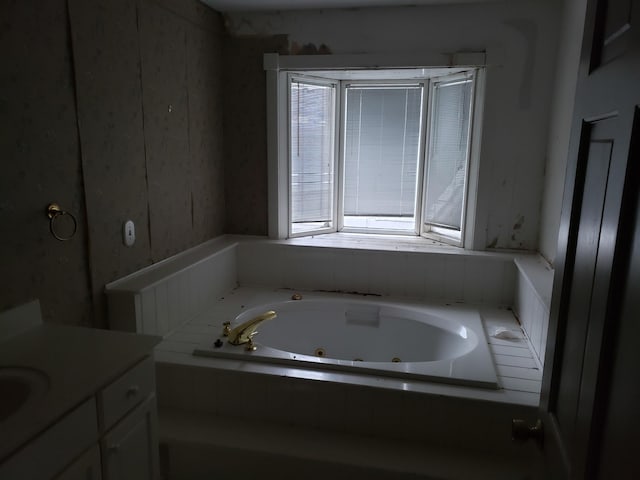 bathroom with tiled bath and vanity