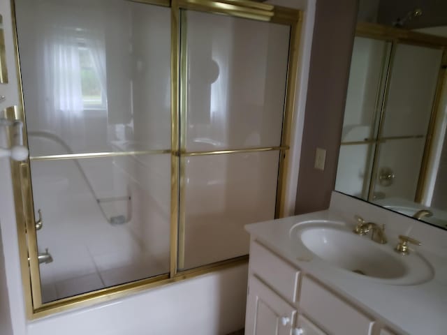 bathroom with vanity and enclosed tub / shower combo