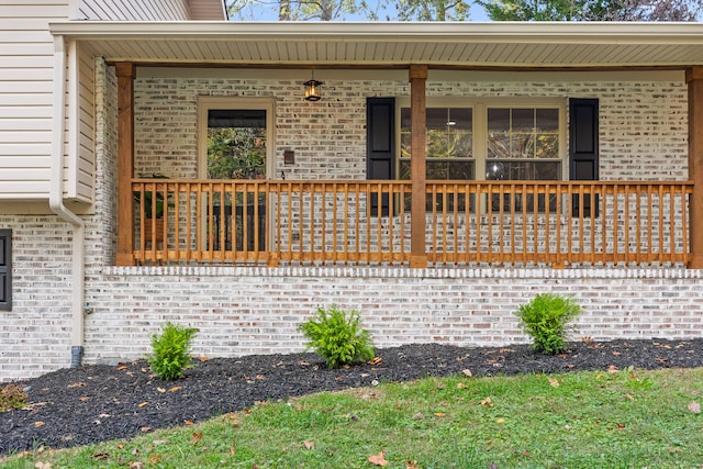 view of exterior entry featuring covered porch