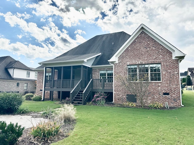 back of property featuring a sunroom and a lawn