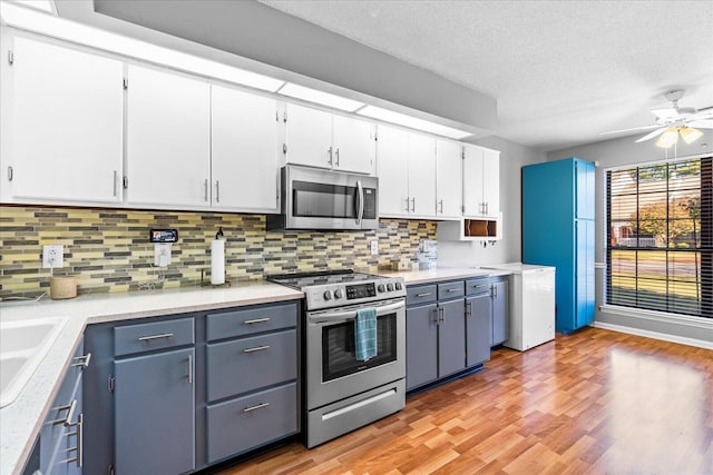 kitchen featuring ceiling fan, stainless steel appliances, a textured ceiling, white cabinets, and light wood-type flooring