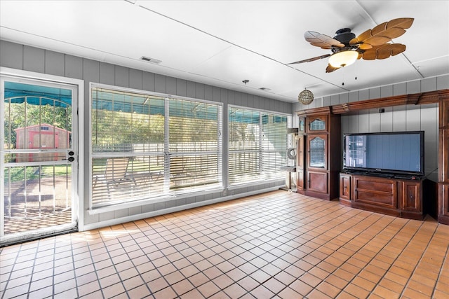 unfurnished sunroom with ceiling fan and a healthy amount of sunlight