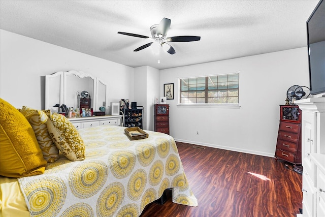 bedroom featuring a textured ceiling, dark hardwood / wood-style floors, and ceiling fan