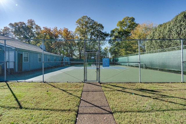 view of tennis court featuring a lawn