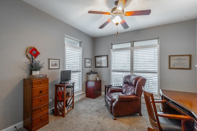 office area with light colored carpet, ceiling fan, and a healthy amount of sunlight