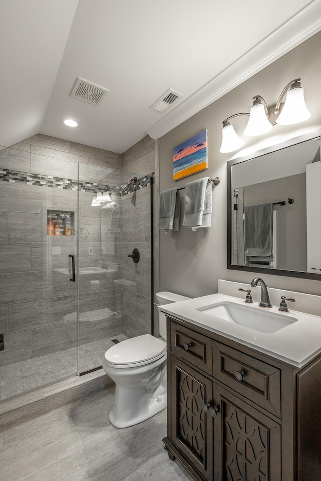 bathroom with walk in shower, vanity, vaulted ceiling, tile patterned flooring, and toilet