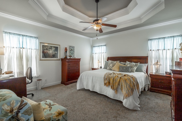 carpeted bedroom featuring a tray ceiling, ceiling fan, and crown molding