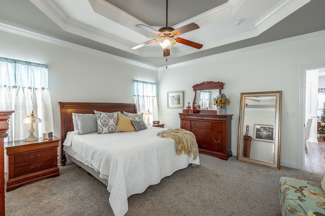 carpeted bedroom featuring a tray ceiling, ceiling fan, and ornamental molding