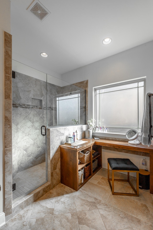 bathroom with plenty of natural light, a shower with door, and vanity