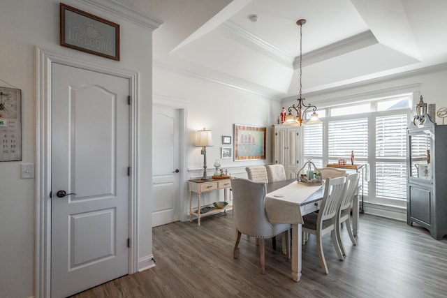 dining room with a notable chandelier, dark hardwood / wood-style flooring, crown molding, and a tray ceiling