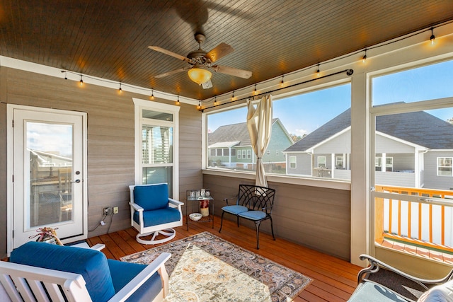 sunroom with ceiling fan and wooden ceiling