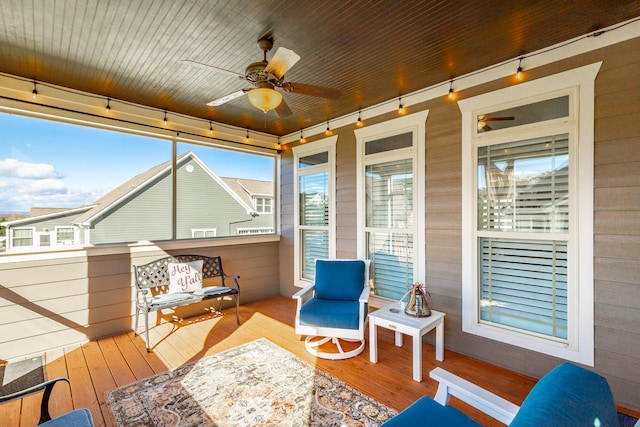 sunroom / solarium featuring ceiling fan, plenty of natural light, and wood ceiling