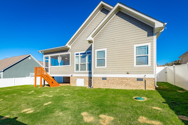 rear view of property with a sunroom and a yard