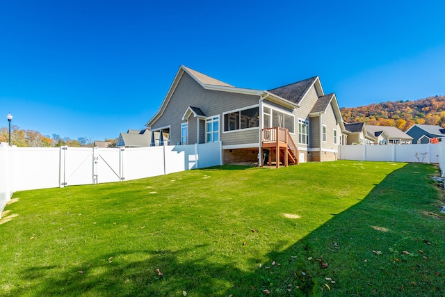 back of house with a lawn and a sunroom