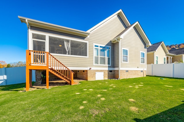 rear view of house featuring a sunroom and a yard