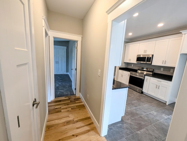 kitchen with backsplash, appliances with stainless steel finishes, and white cabinets