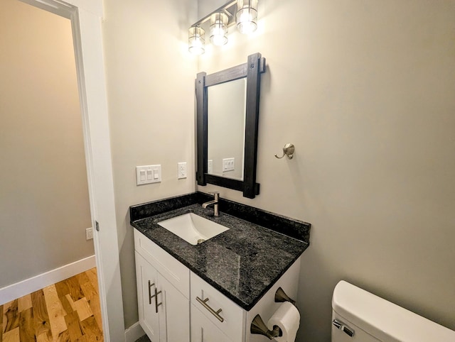 bathroom with vanity, wood-type flooring, and toilet