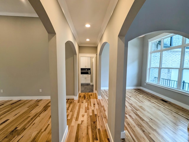 hall featuring crown molding and light hardwood / wood-style flooring