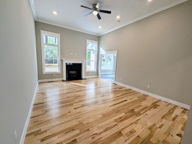 unfurnished living room with ceiling fan, ornamental molding, and light hardwood / wood-style floors