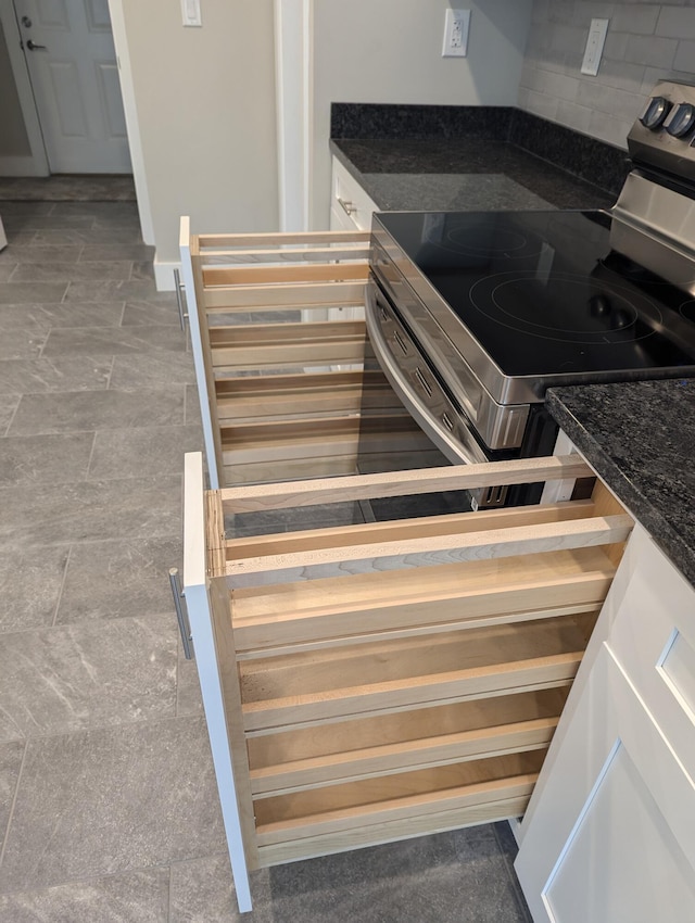 interior details with stainless steel electric range and backsplash