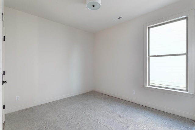 spare room featuring light carpet